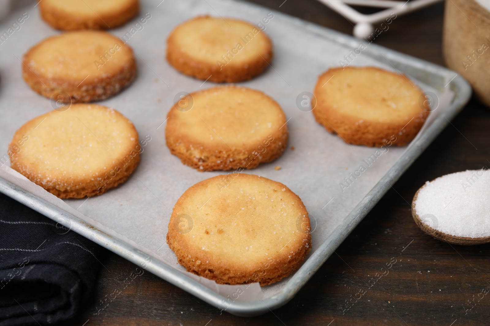 Photo of Tray with tasty sweet sugar cookies on wooden table, closeup