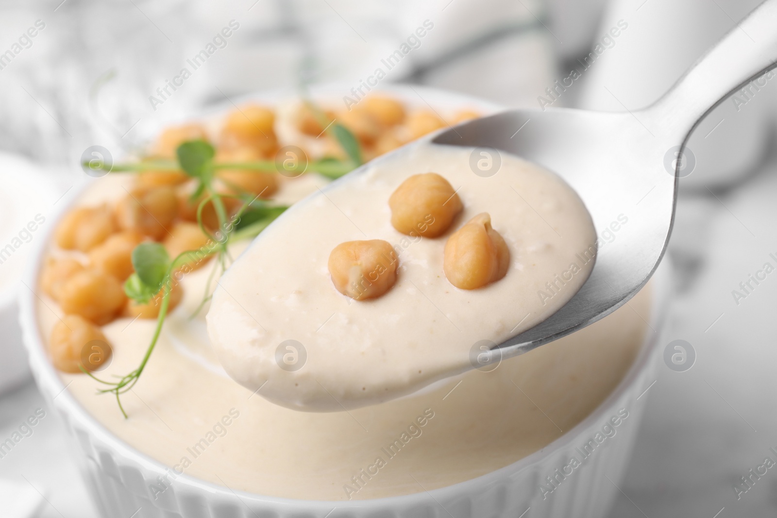 Photo of Eating tasty chickpea soup on table, closeup