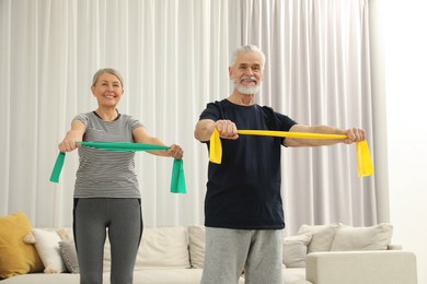 Senior couple doing exercise with fitness elastic bands at home