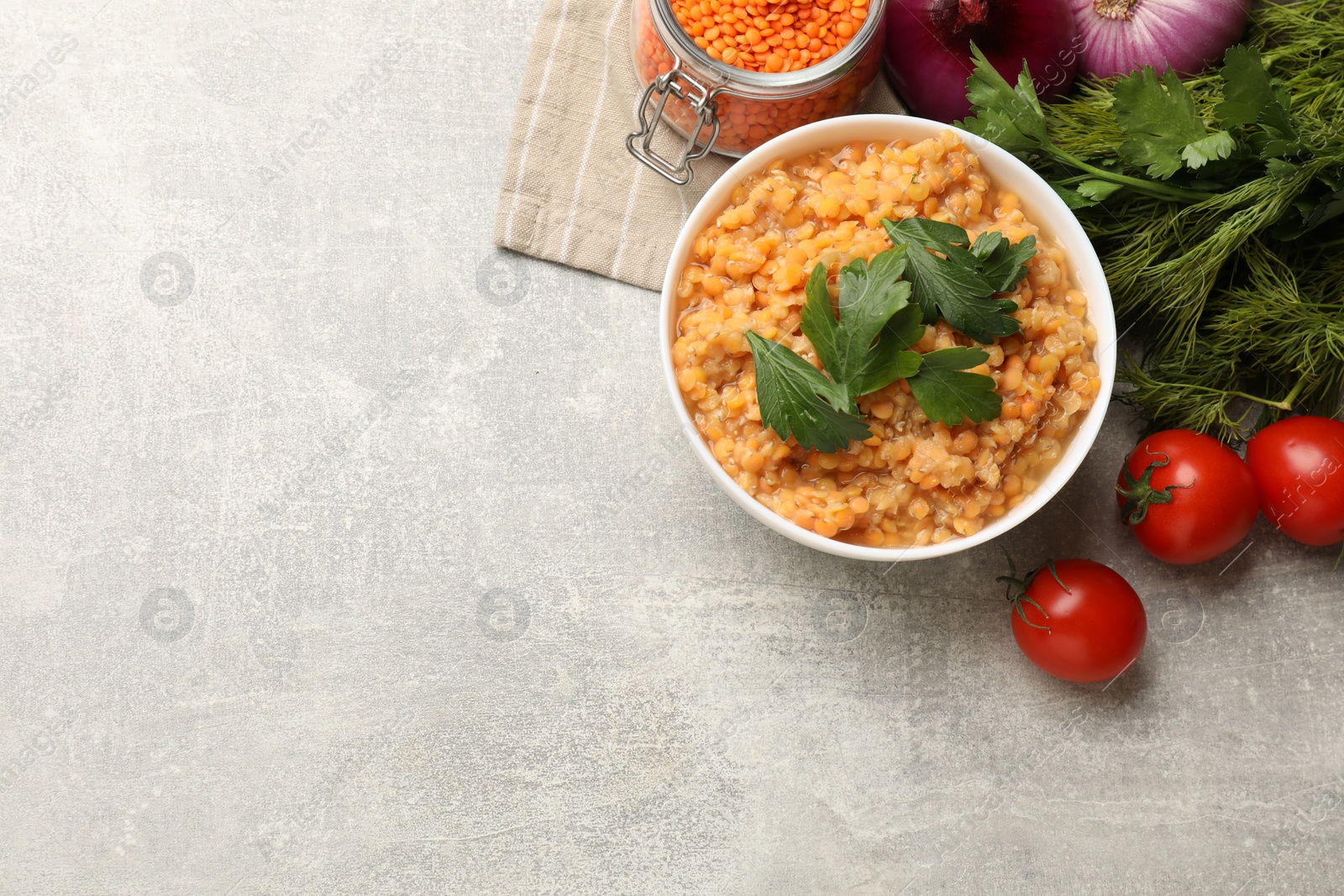 Photo of Delicious red lentils and products on light grey table, top view. Space for text