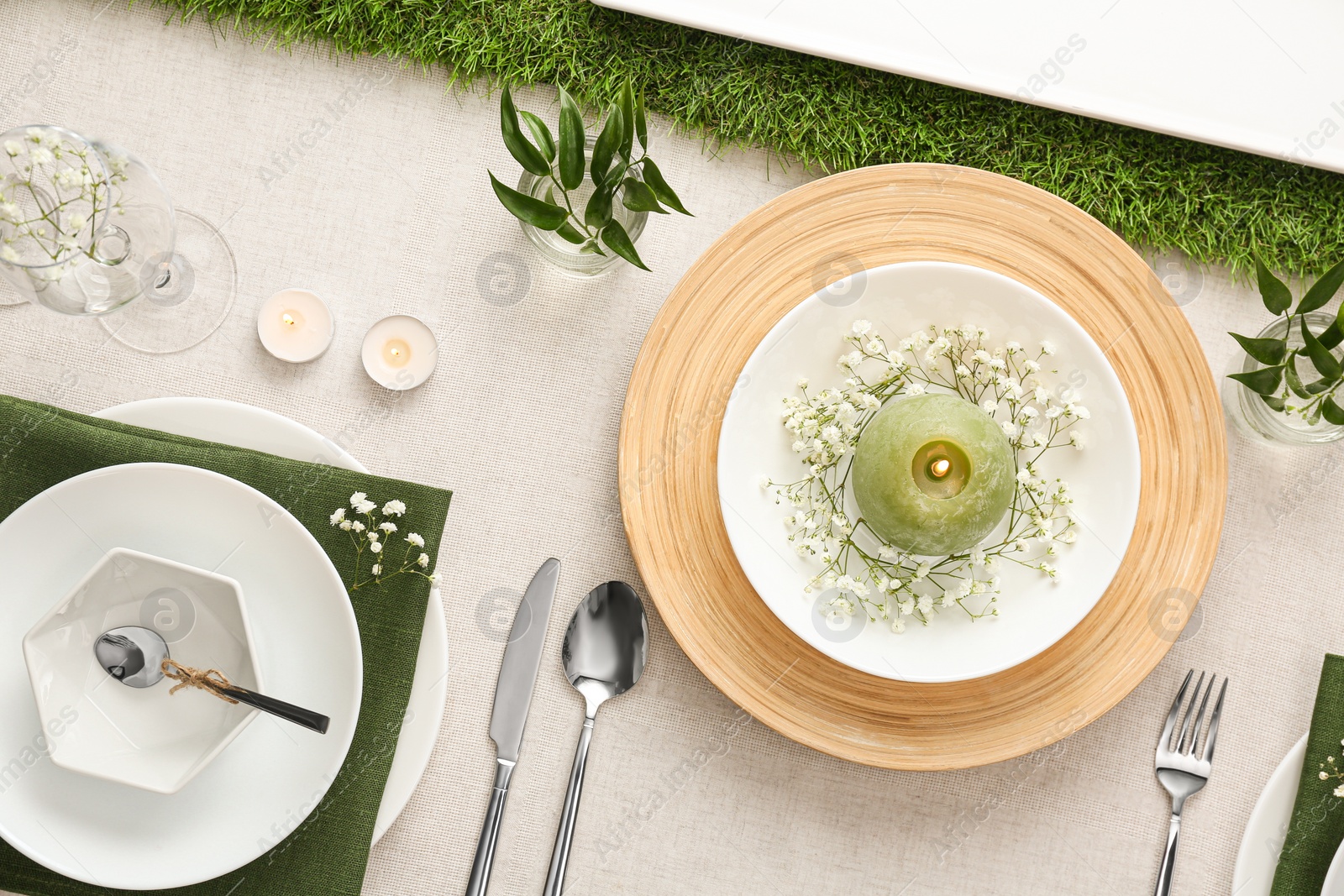 Photo of Elegant table setting with green plants on light cloth, flat lay