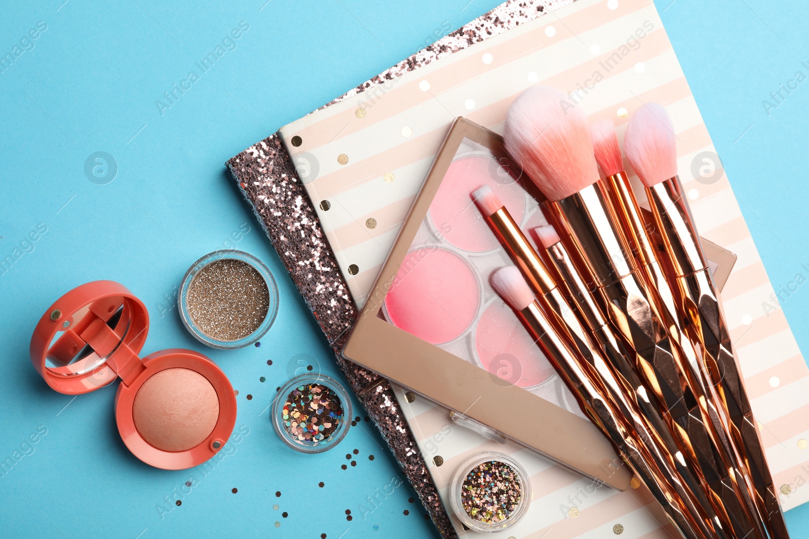 Photo of Flat lay composition with coral cosmetics and notebooks on light blue background