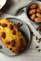 Photo of Delicious pumpkin bread with pecan nuts on light wooden table, flat lay