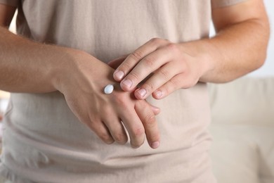 Man applying hand cream at home, closeup