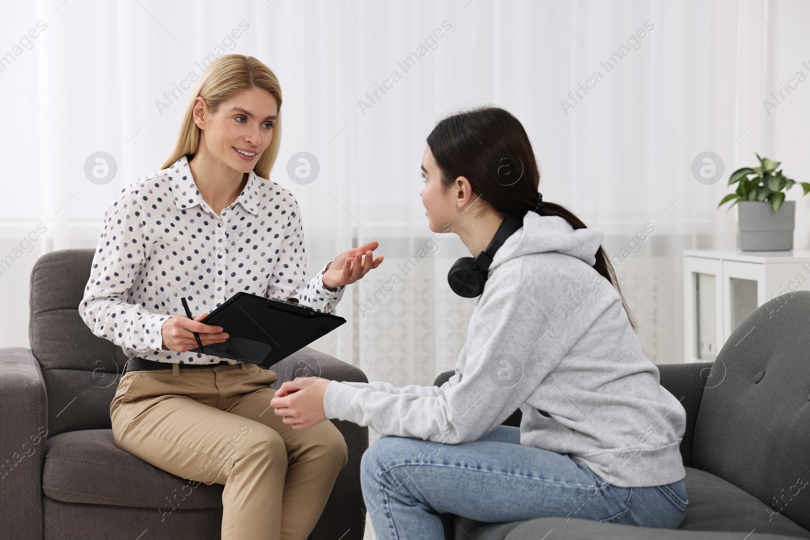 Photo of Psychologist working with teenage girl in office