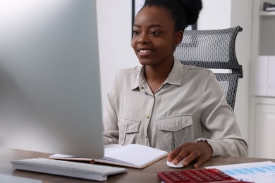 Photo of Professional accountant working on computer at wooden desk in office