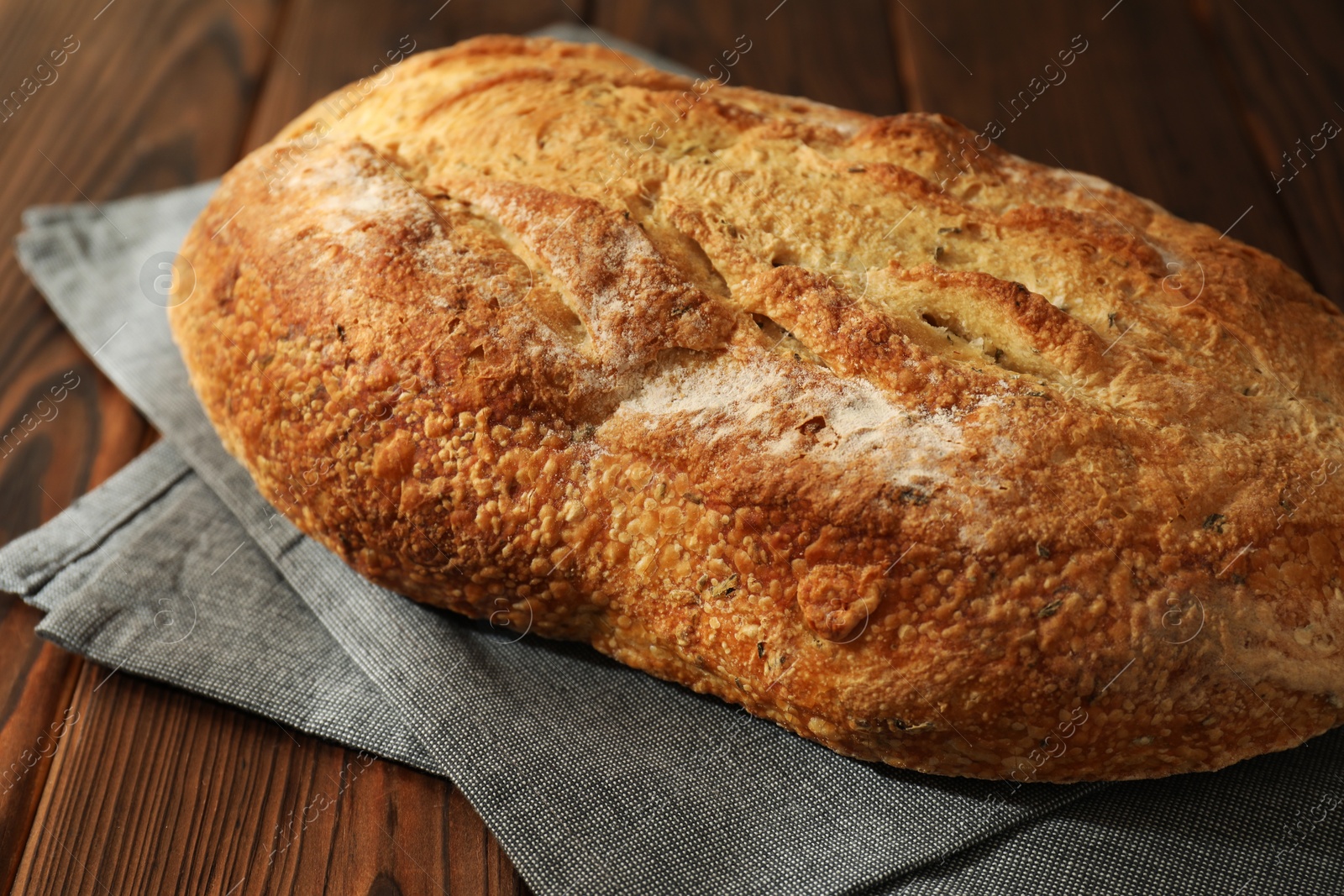 Photo of Freshly baked sourdough bread on wooden table, closeup