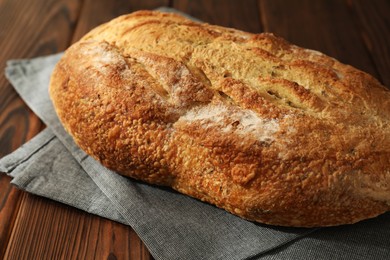 Photo of Freshly baked sourdough bread on wooden table, closeup