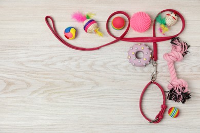 Photo of Flat lay composition with pet leash and toys on white wooden background, space for text