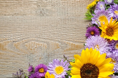 Photo of Flat lay composition with beautiful asters and sunflowers on wooden table. Space for text