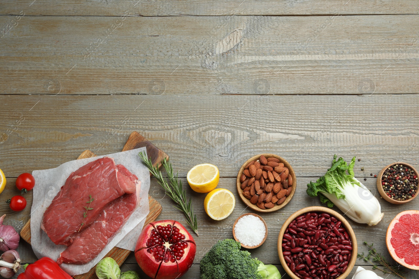 Photo of Flat lay composition with fresh meat and other products on wooden table, space for text. Balanced diet