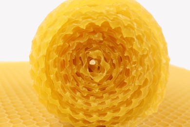 Stylish elegant beeswax candle and wax sheet on white background, closeup