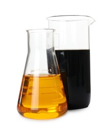 Photo of Beaker and flask with different types of crude oil isolated on white