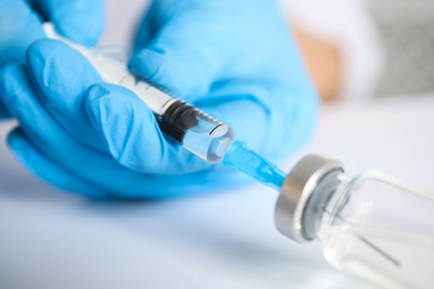 Photo of Doctor filling syringe with medication, closeup. Vaccination and immunization