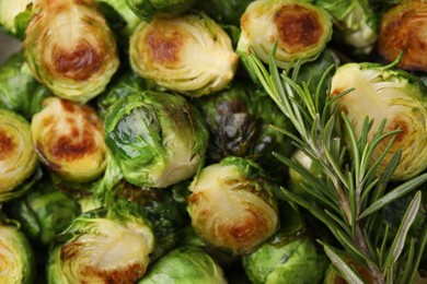 Photo of Delicious roasted Brussels sprouts and rosemary as background, top view