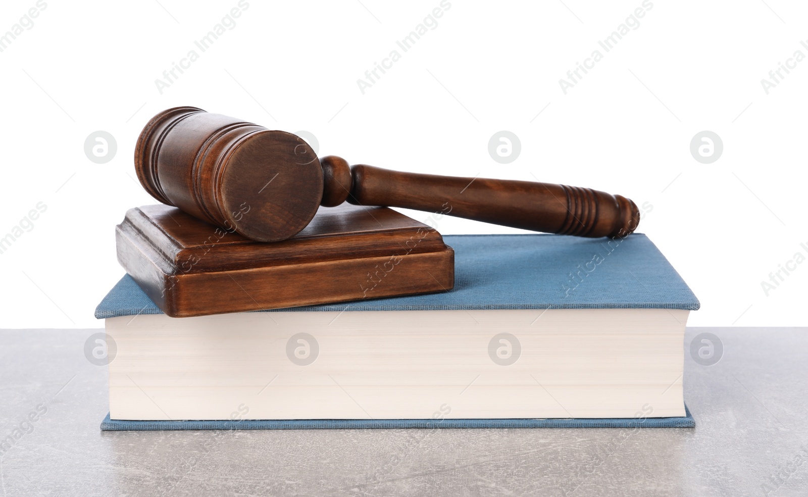 Photo of Wooden gavel, sound block and book on light table against white background