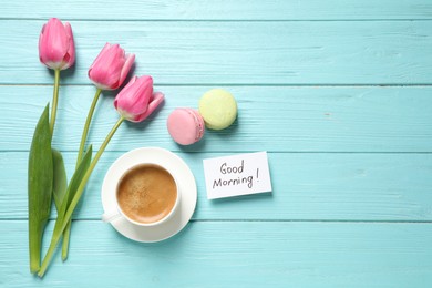 Flat lay composition with message GOOD MORNING and coffee on light blue wooden table. Space for text