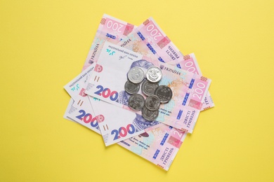Photo of Ukrainian money on yellow background, flat lay