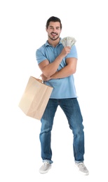 Handsome young man with dollars and shopping bag on white background