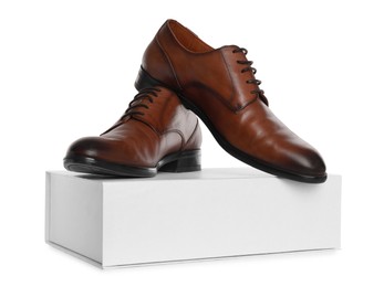 Photo of Pair of stylish leather shoes and box on white background