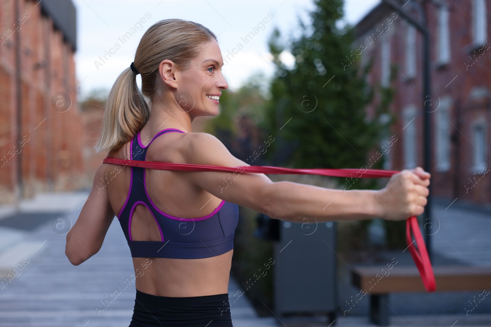 Photo of Fit woman doing exercise with fitness elastic band outdoors