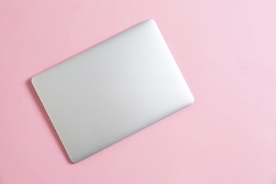 Modern laptop on color background, top view