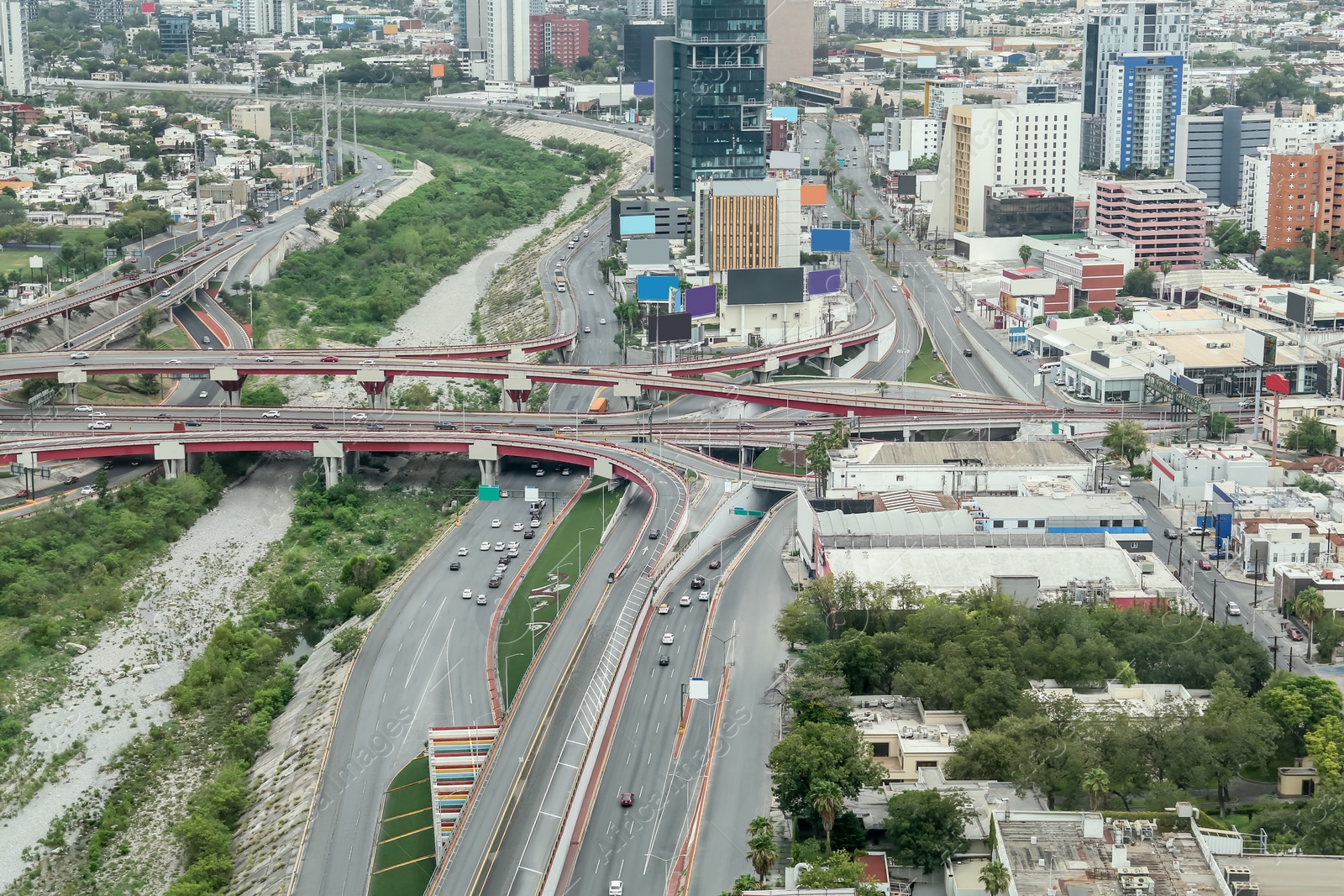 Photo of Panoramic view on city with asphalt highway, many trees and buildings