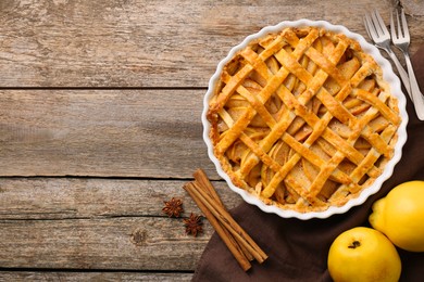 Photo of Tasty homemade quince pie served on wooden table, flat lay. Space for text