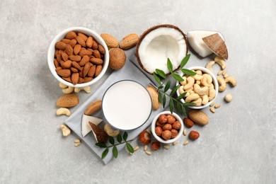 Photo of Vegan milk and different nuts on light table, flat lay