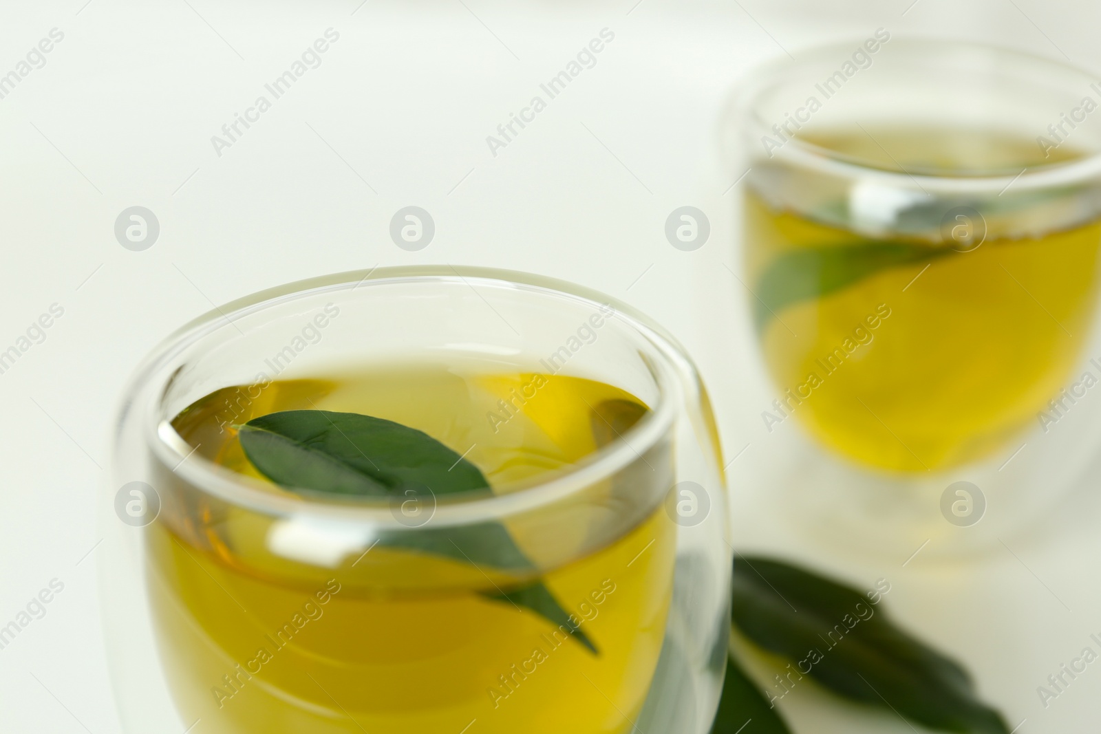 Photo of Aromatic green tea on light background, closeup