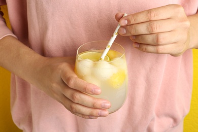 Photo of Woman holding glass of melon ball cocktail with straw, closeup