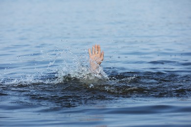 Photo of Drowning man reaching for help in sea, closeup