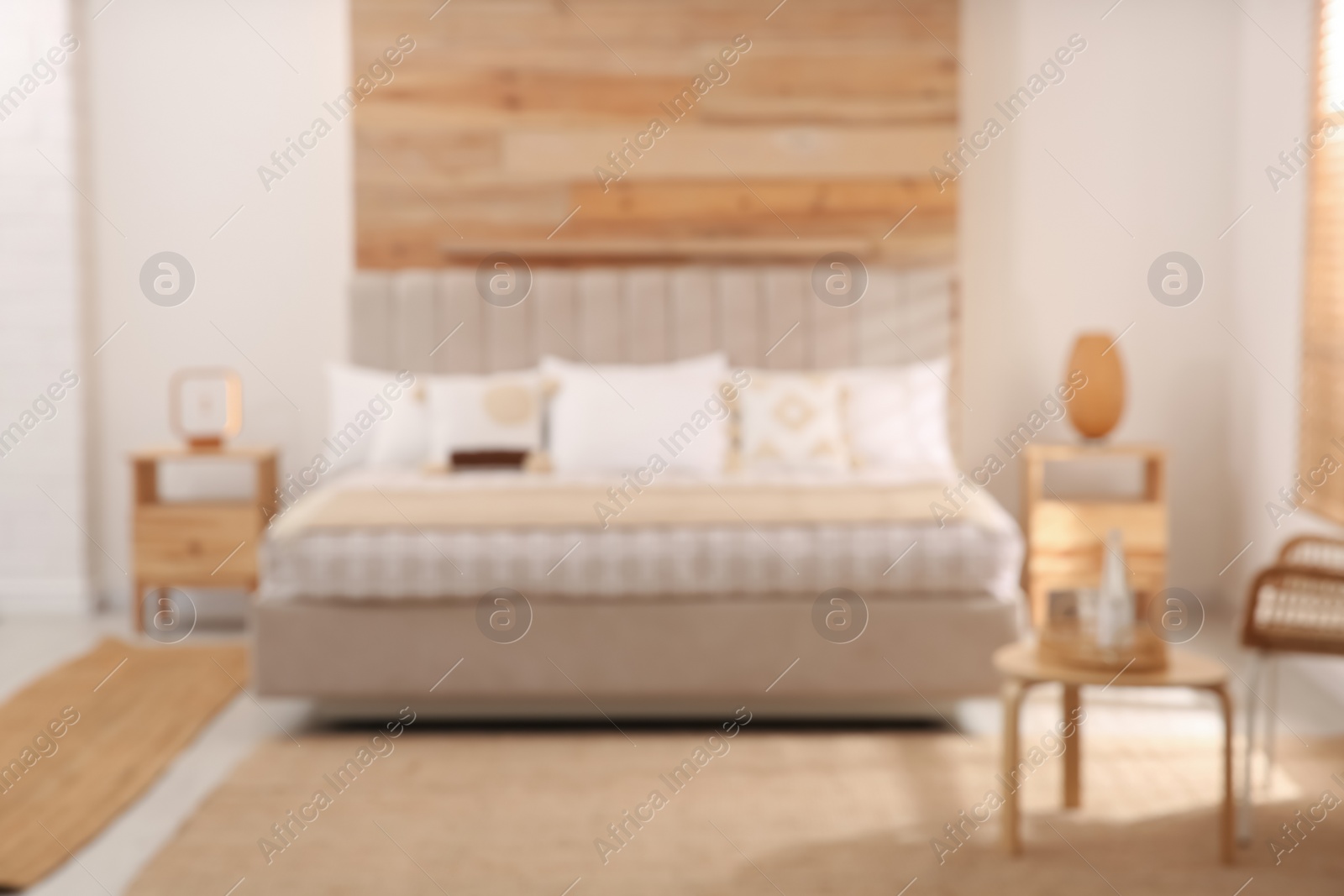 Photo of Blurred view of stylish hotel room interior with comfortable bed