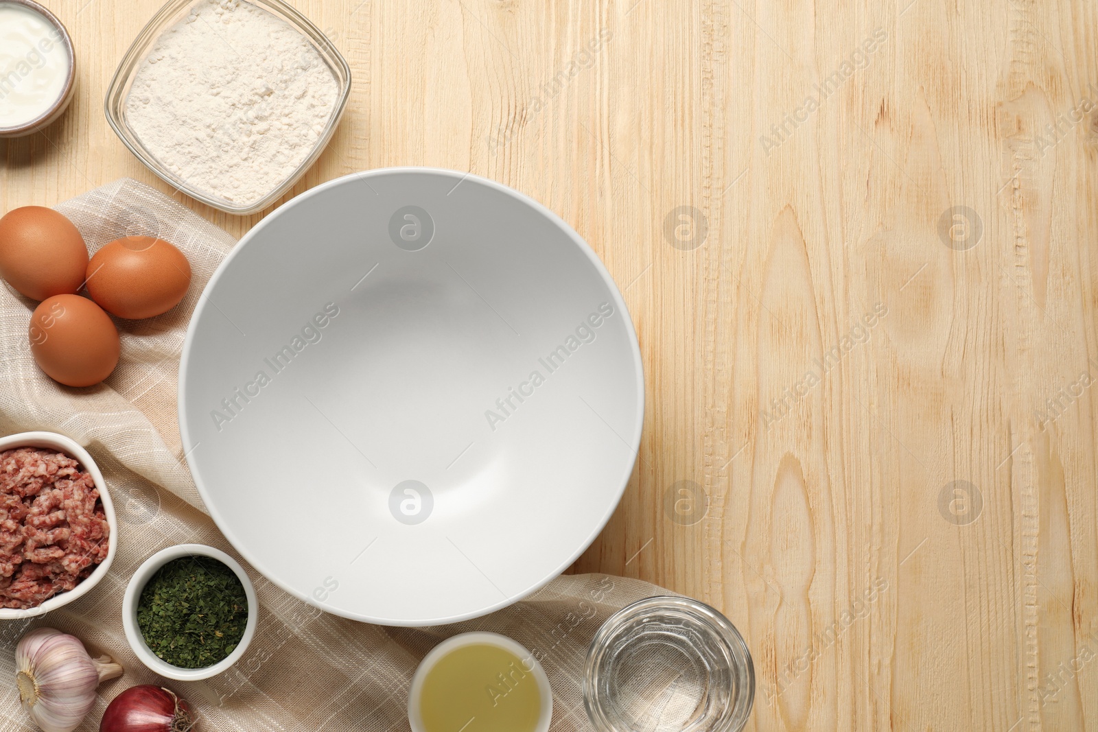 Photo of Bowl and different products on wooden table, flat lay. Space for text