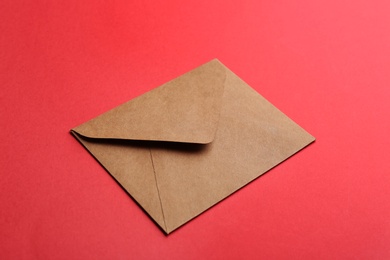 Photo of Brown paper envelope on red background. Mail service