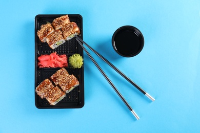 Photo of Flat lay composition with sushi rolls on color background. Food delivery