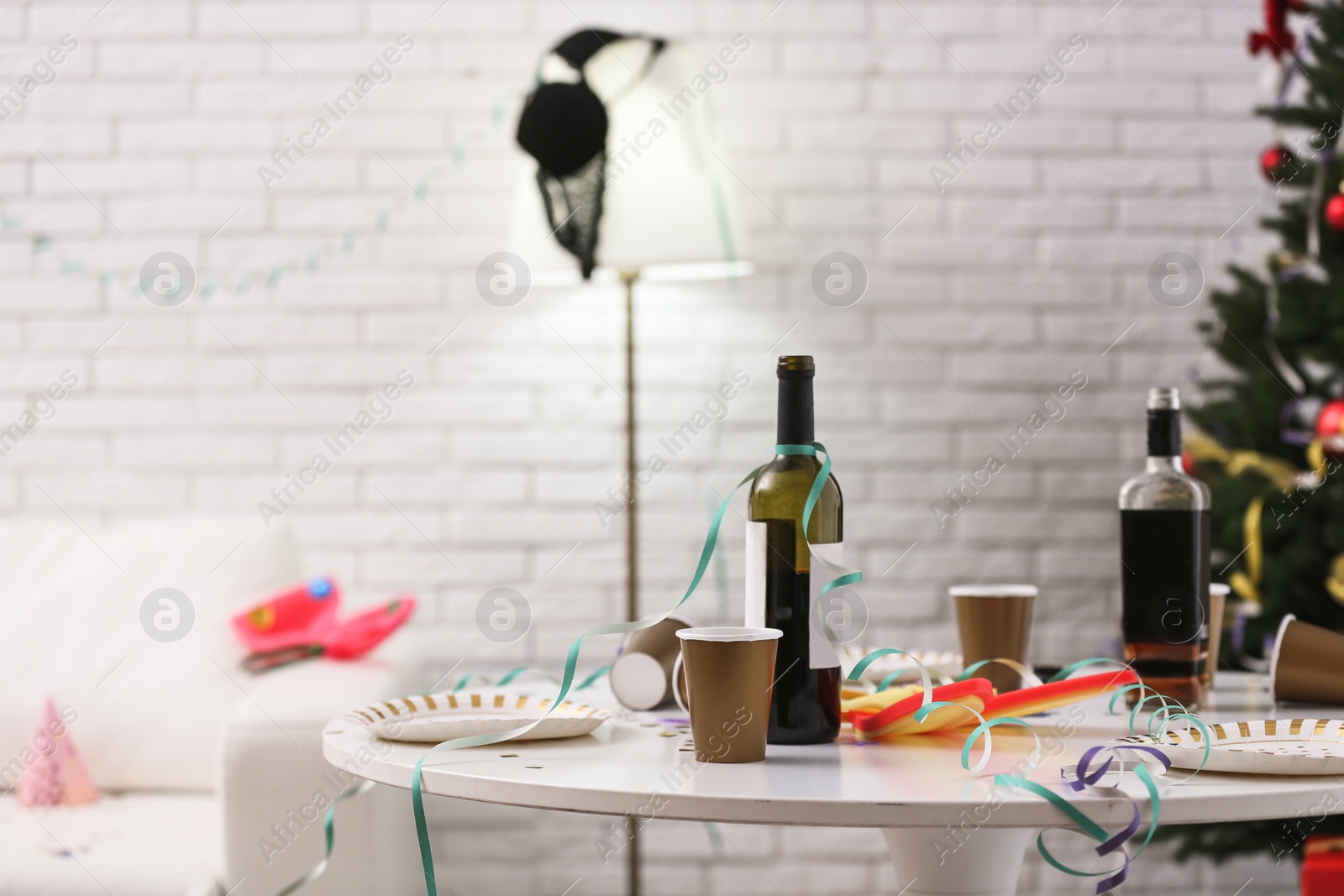 Photo of Messy table with cups and bottles indoors, space for text. Chaos after party