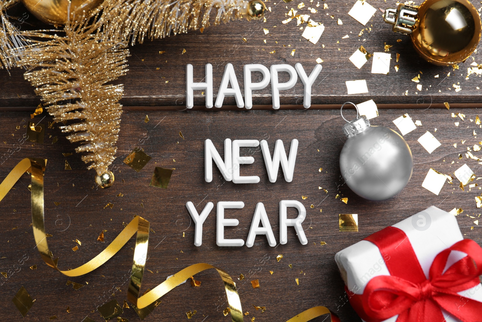 Photo of Flat lay composition with phrase Happy New Year and festive decor on wooden background