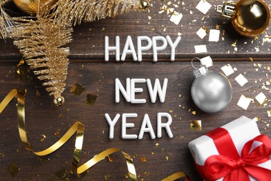 Photo of Flat lay composition with phrase Happy New Year and festive decor on wooden background