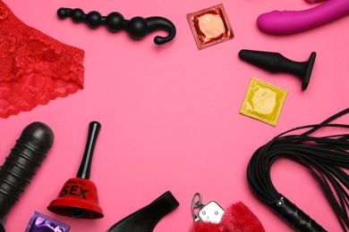 Different sex toys on pink background, flat lay. Space for text