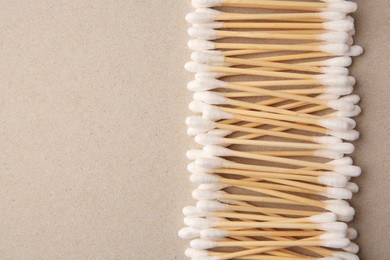 Photo of Many clean cotton buds on cardboard, flat lay. Space for text