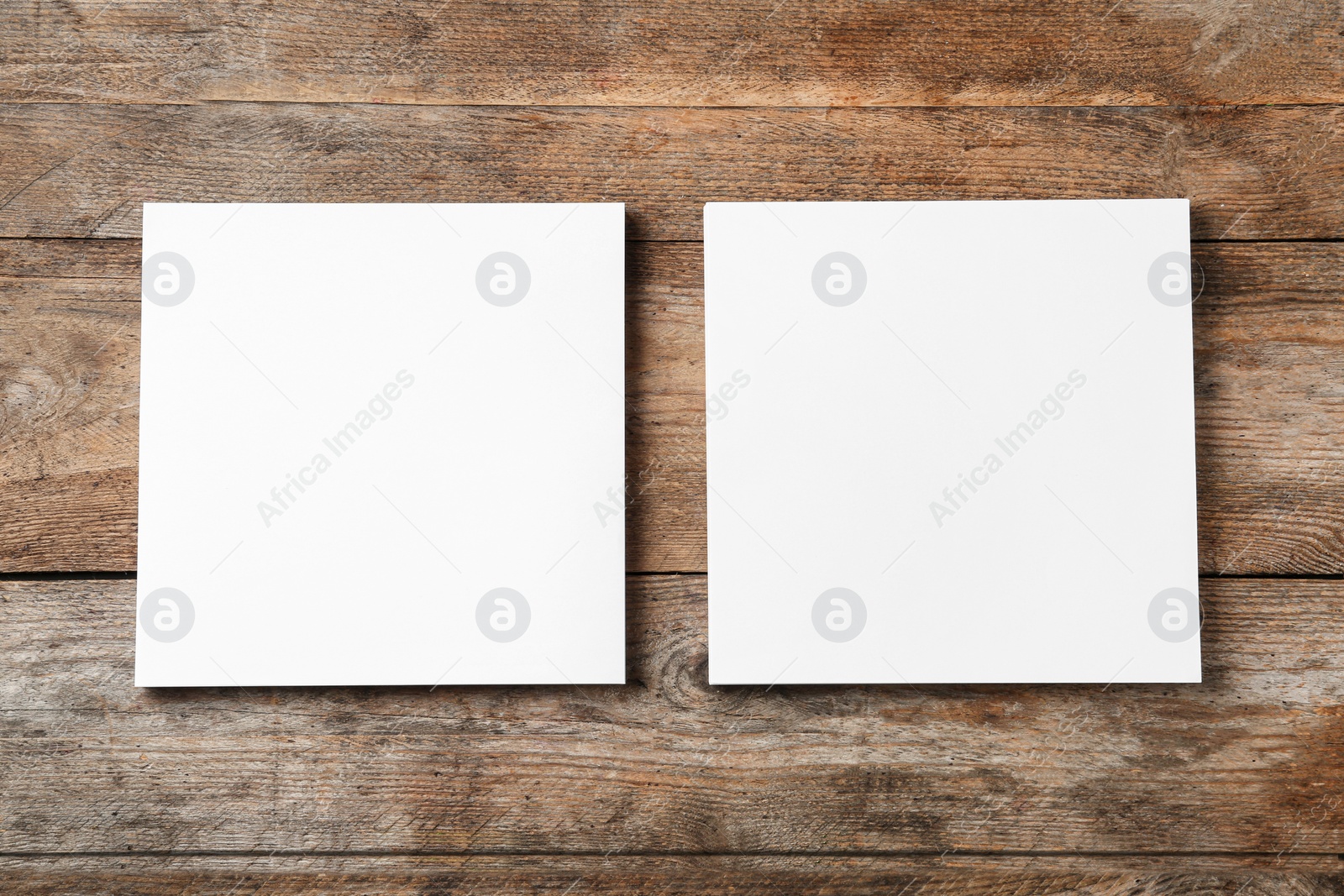 Photo of Blank paper sheets for brochure on wooden background, flat lay. Mock up