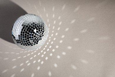 Photo of Shiny disco ball on light grey background, top view. Space for text