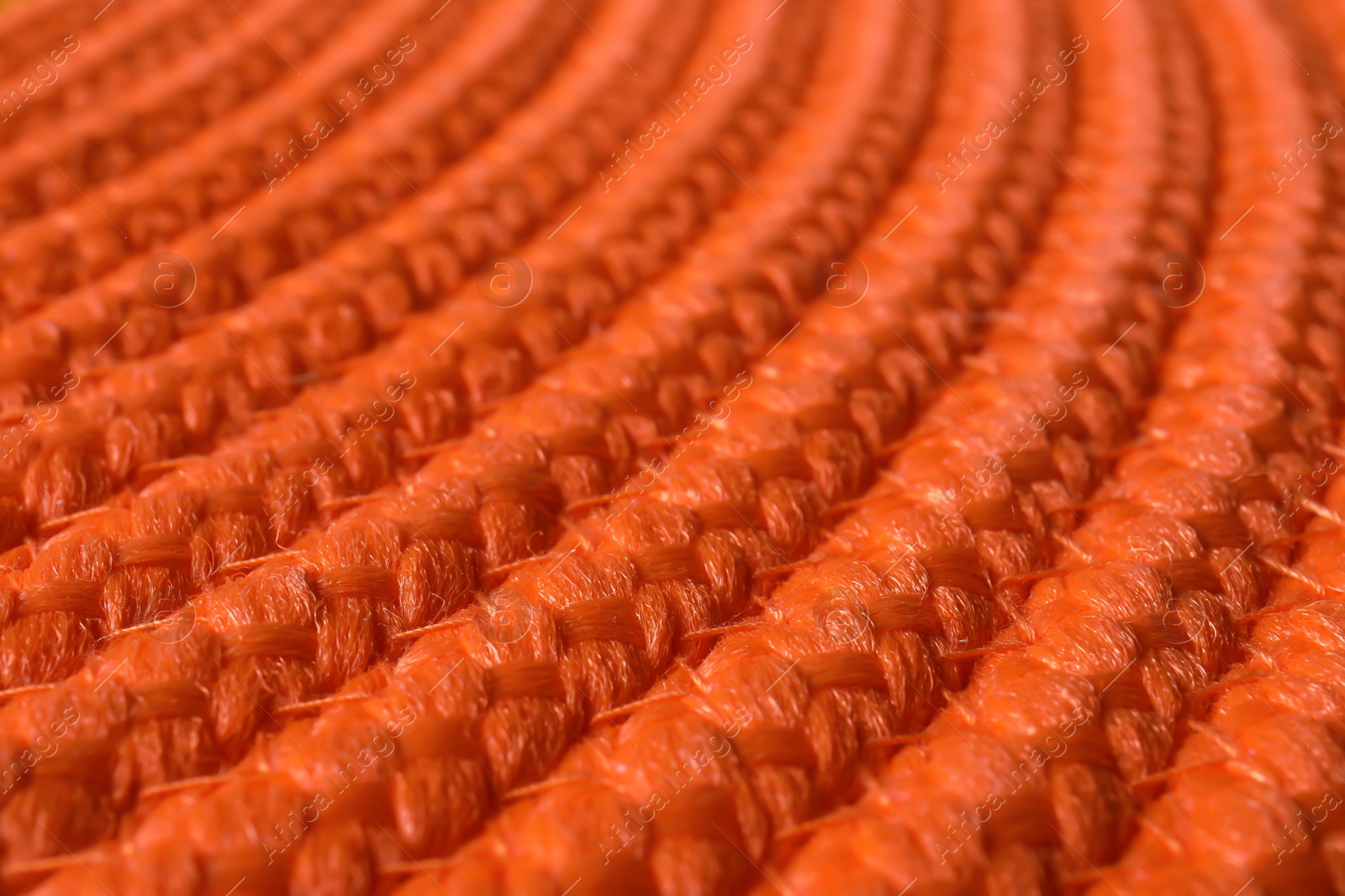 Photo of Orange wicker mat texture as background, closeup