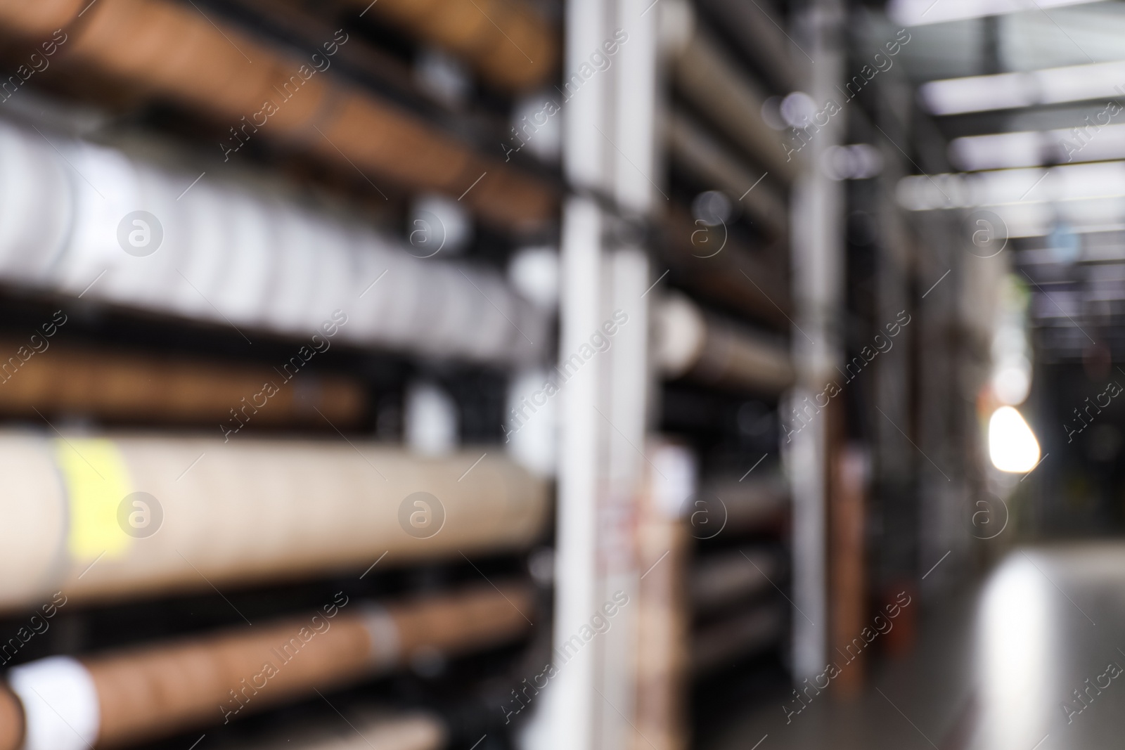 Photo of Blurred view of storage stands with different building materials in wholesale warehouse