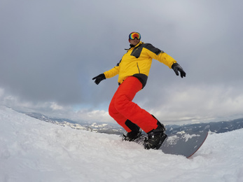 Photo of Man snowboarding at ski resort. Winter vacation