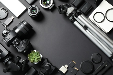 Photo of Flat lay composition with camera and video production equipment on black background. Space for text