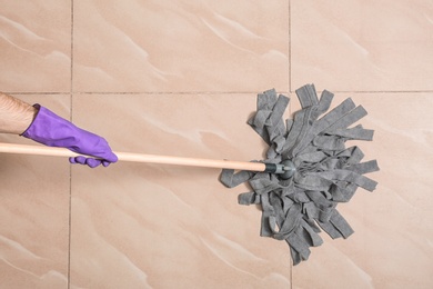 Photo of Man cleaning floor with mop, top view