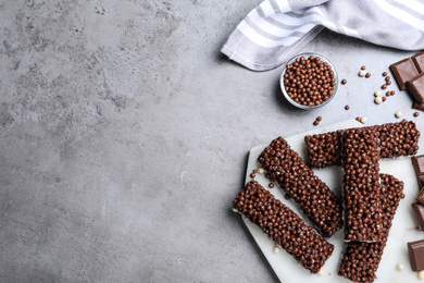 Photo of Delicious rice crispy treats on grey table, flat lay. Space for text