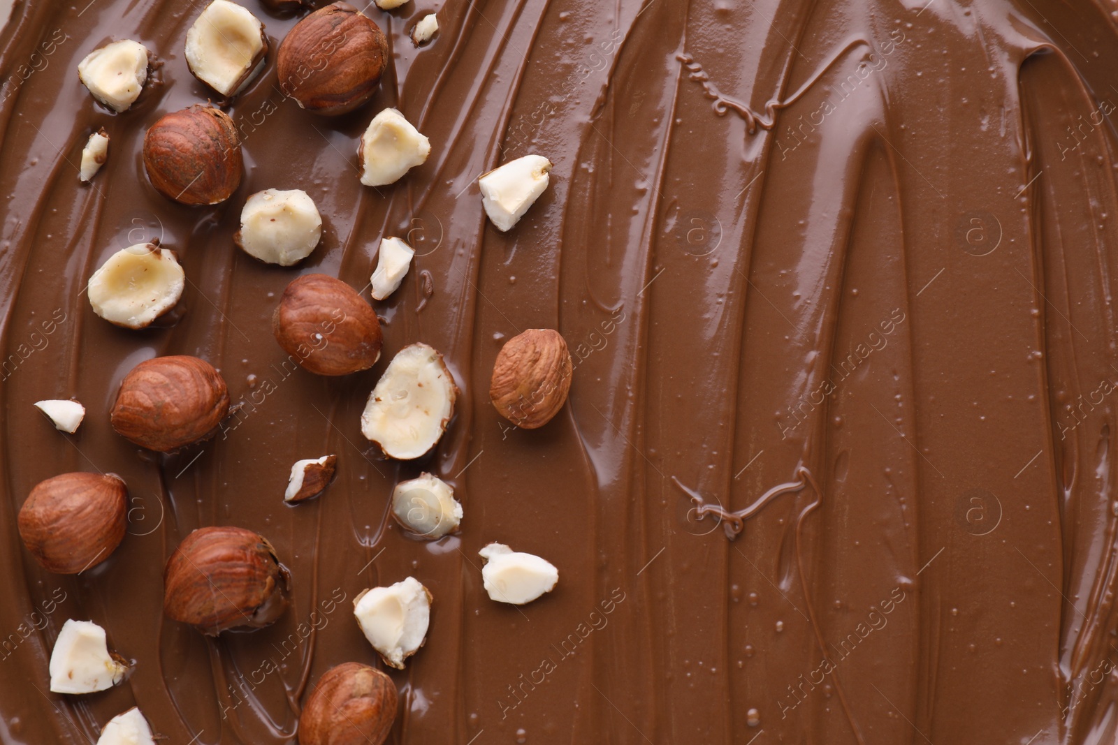 Photo of Delicious chocolate paste with nuts as background, top view